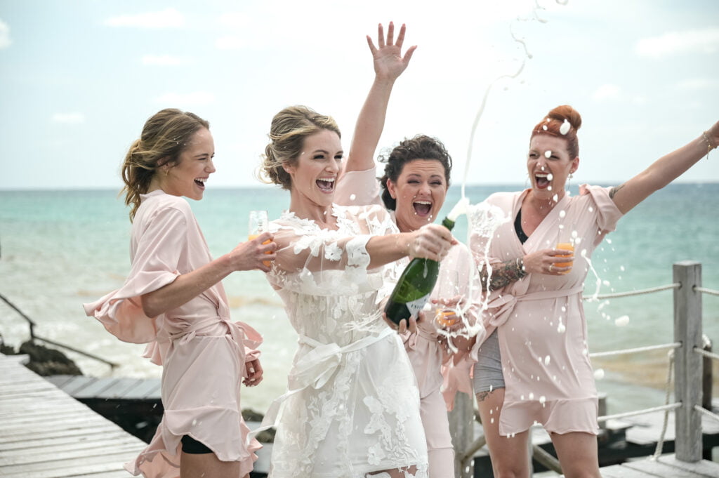 Bridemaids celebrating during a Riviera Maya destination wedding photography by Poga Studios