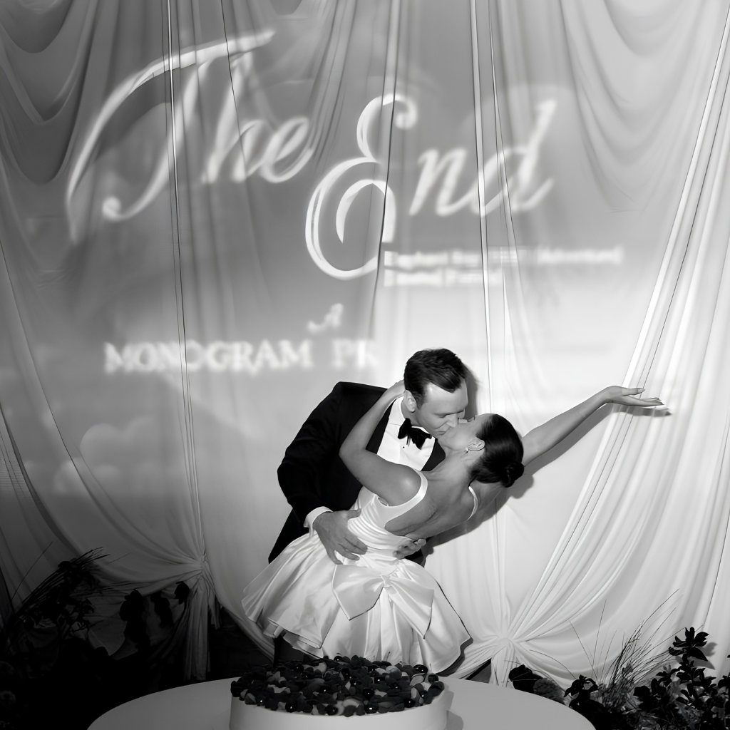 Bride and groom celebrating diring the reception, behind a projecyion mapping